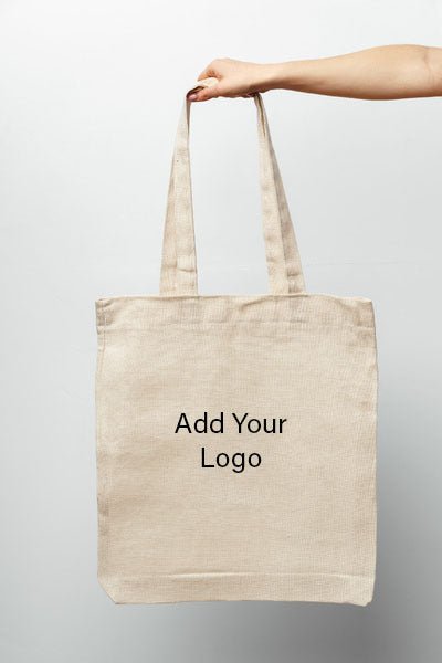 Holding PackQueen plain calico tote bag with custom logo placeholder